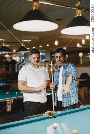 Men playing billiards in a club 78960530