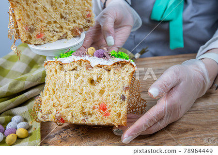 Female hands hold a cut Easter cake made from yeast dough 78964449