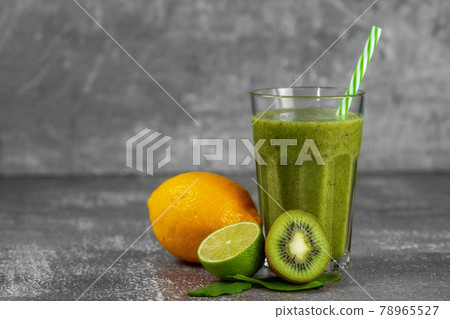 Fresh healthy smoothie drink in a tall glass glass with fruits on gray 78965527