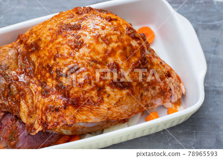 raw turkey leg with spices and vegetables on dish on ceramic background 78965593