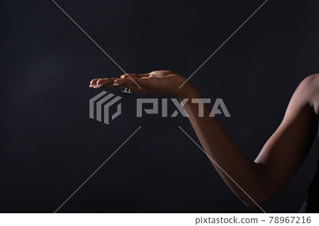 Empty female hand of african american woman holding on black background 78967216