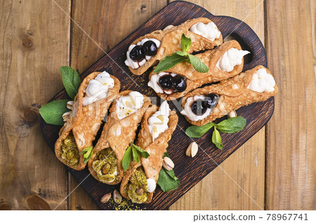 Cannoli Sicily. Traditional Italian sweet with ricotta and various fillings. Food on a wooden 78967741