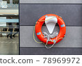 Orange and white lifebuoy hanging on the wall on marine 78969972