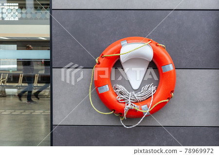 Orange and white lifebuoy hanging on the wall on marine 78969972