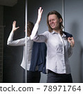 portrait of an emotional business woman taking off her jacket, smiling happily 78971764