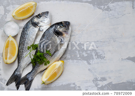 raw fish with olive oil and lemon background raw fish with olive oil and lemon background 78972009