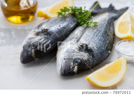 raw fish with olive oil and lemon background raw fish with olive oil and lemon background 78972011