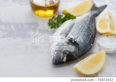 raw fish with olive oil and lemon background 78972012