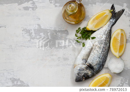 raw fish with olive oil and lemon background raw fish with olive oil and lemon background 78972013