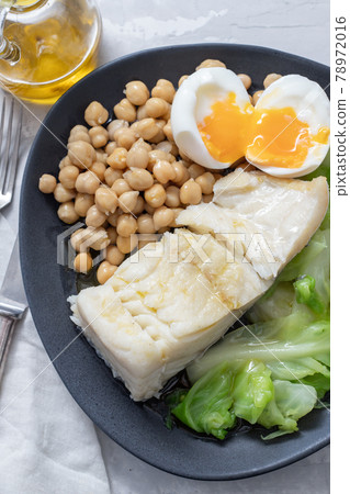 fried cod fish with chick pea, boiled egg and cabbage on dark dish fried cod fish with chick pea, boiled egg and cabbage on dark dish 78972016
