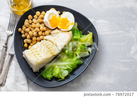 fried cod fish with chick pea, boiled egg and cabbage on dark dish fried cod fish with chick pea, boiled egg and cabbage on dark dish 78972017