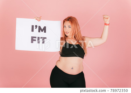 Beautiful strong woman with plus size body showing placard Beautiful strong woman with plus size body showing placard 78972350