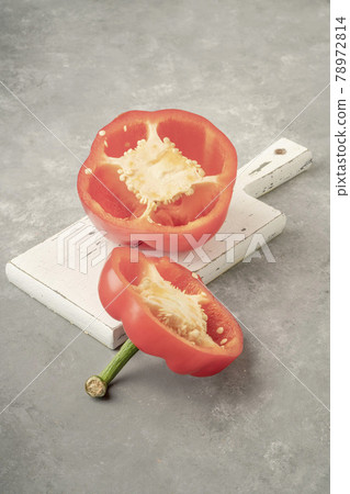 halved red bell pepper on a wooden cutting board on gray background halved red bell pepper on a wooden cutting board on gray background 78972814