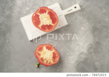 halved red bell pepper on a wooden cutting board on gray background halved red bell pepper on a wooden cutting board on gray background 78972815