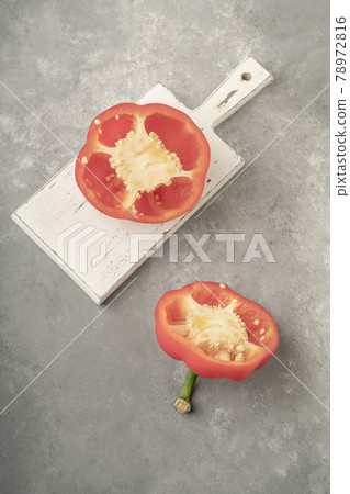 halved red bell pepper on a wooden cutting board on gray background halved red bell pepper on a wooden cutting board on gray background 78972816