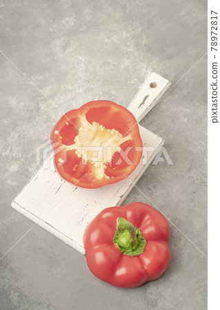 halved red bell pepper on a wooden cutting board on gray background halved red bell pepper on a wooden cutting board on gray background 78972817