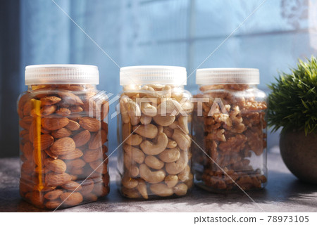 walnut , cashew nut and almond in a container on table walnut , cashew nut and almond in a container on table 78973105