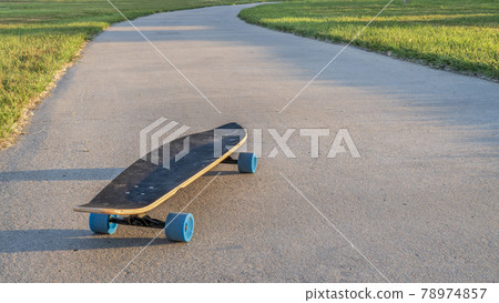 cruising longboard on a bike trail cruising longboard on a bike trail 78974857