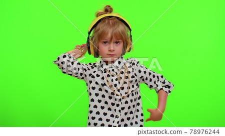 Attractive blonde child kid listening music via headphones dancing disco fooling having fun party 78976244
