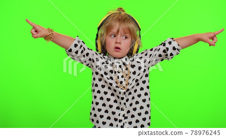 Funny playful blonde child kid listening music via headphones dancing disco fooling having fun party 78976245