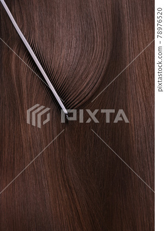 A closeup view of a bunch of shiny straight brown hair 78976520
