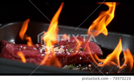 Super slowmotion footage of flambe fresh beef meat and seasoning on ignited pan, 1000fps 4k 78978228