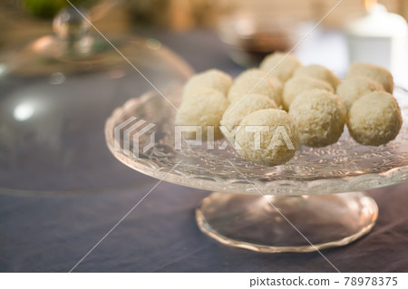 Cakes with coconut truffles in the evening light on a stand Cakes with coconut truffles in the evening light on a stand 78978375