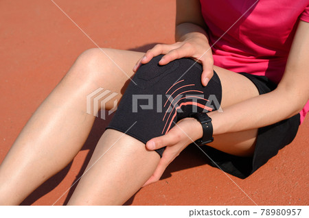 Cropped shot of runner woman suffering from knee pain and she wearing knee braces for supports to be worn when you have pain in your knee. 78980957