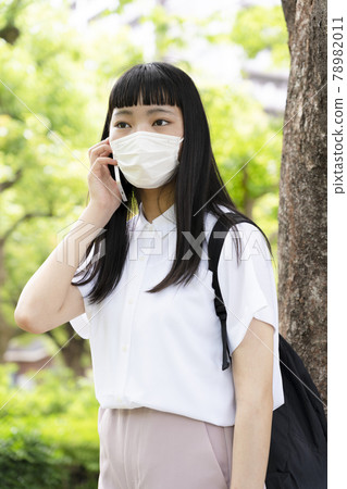 一個戴著面具在樹邊打電話的女孩 一個戴著面具在樹邊打電話的女孩 78982011