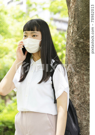 一個戴著面具在樹邊打電話的女孩 一個戴著面具在樹邊打電話的女孩 78982013
