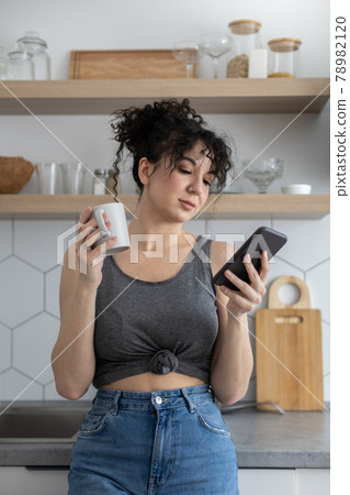 Joyful brunette woman chatting surfing internet use smartphone enjoying coffee break at cafe Joyful brunette woman chatting surfing internet use smartphone enjoying coffee break at cafe 78982120