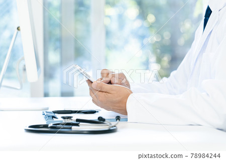 At the hands of a doctor who operates a smartphone At the hands of a doctor who operates a smartphone 78984244