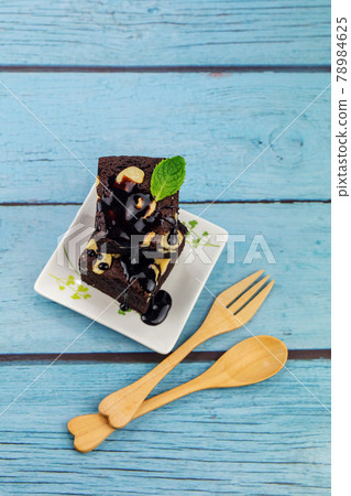 Homemade chocolate brownie on a blue wood background With wooden cutlery , bakery and dessert 78984625