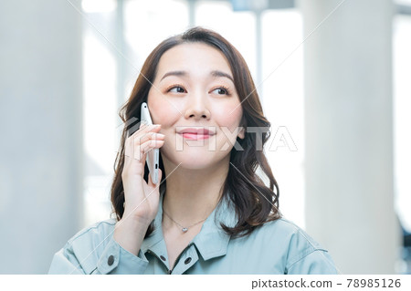 穿著工作服的女工程師在辦公室打電話給智能手機 78985126