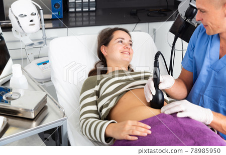 Woman getting ultrasound procedure for body contouring 78985950