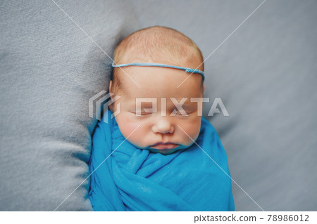 the face of a child with a bandage with flowers on his head close-up 78986012
