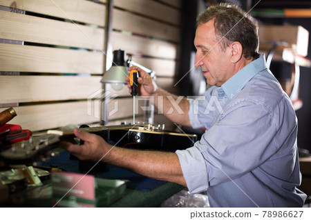 Music master is repairing music instruments Music master is repairing music instruments 78986627