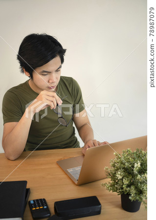 Serious man freelancer working online with laptop at home. 78987079