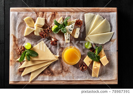 Sliced sulguni, mozzarella, dor blue and semi firm cheeses on wooden board Sliced sulguni, mozzarella, dor blue and semi firm cheeses on wooden board 78987391