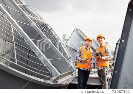 Asian male engineer inspecting pipe fittings and chillers, refrigeration plant refrigeration plant in  factory. male mechanic wearing helmet and Reflective Safety Vest uses laptop, tablet, equipment 78987593