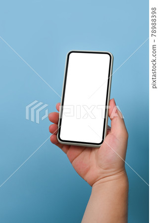 Cropped shot man holding mock up mobile phone over blue background. 78988398