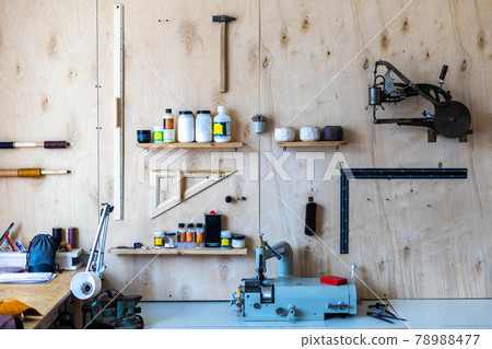 Wooden wall at leather workshop. Different tools and equipment for handcraft working tanner 78988477