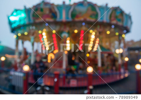 A blurry colorful carousel in the amusement park at evening illumination. The effect of bokeh 78989349