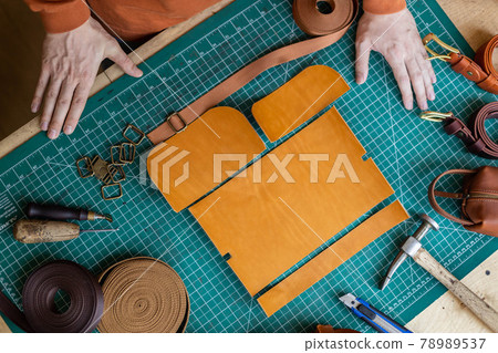 Process cutting scheme of bag with equipment and materials. Male tanner working at leather workshop 78989537