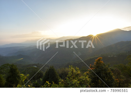藍天白雲，山峰煙霞繚繞，日出景色玲瓏飄逸，目光如旭日，四道光柱熠熠生輝。 78990381