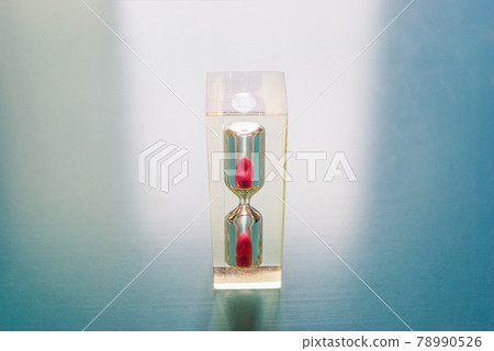 亞克力沙漏,沙子落在藍色塑料板的中心 亞克力沙漏,沙子落在藍色塑料板的中心 78990526