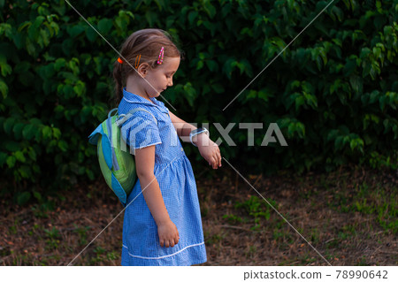 Kid using smartwatch outdoor. Child talking on the smartphone. Schoolgirl using touchscreen on watches browsing internet Kid using smartwatch outdoor. Child talking on the smartphone. Schoolgirl using touchscreen on watches browsing internet 78990642