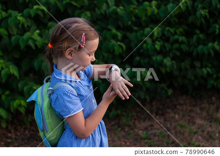 Kid using smartwatch outdoor. Child talking on the smartphone. Schoolgirl using touchscreen on watches browsing internet Kid using smartwatch outdoor. Child talking on the smartphone. Schoolgirl using touchscreen on watches browsing internet 78990646