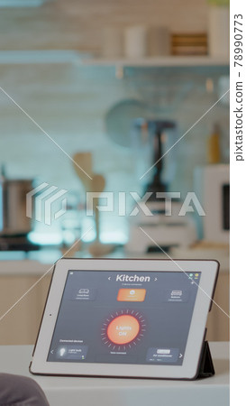 Man looking at tablet with intelligent software placed on kitchen table 78990773