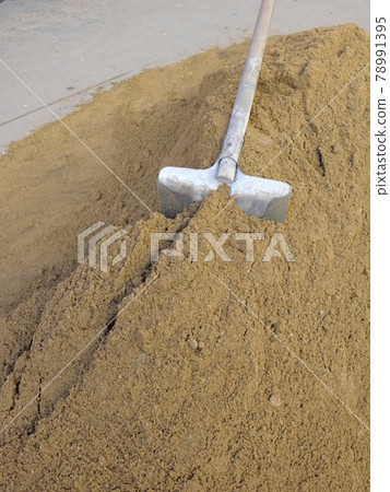A shovel sticks out in a pile of sand. A shovel sticks out in a pile of sand. 78991395
